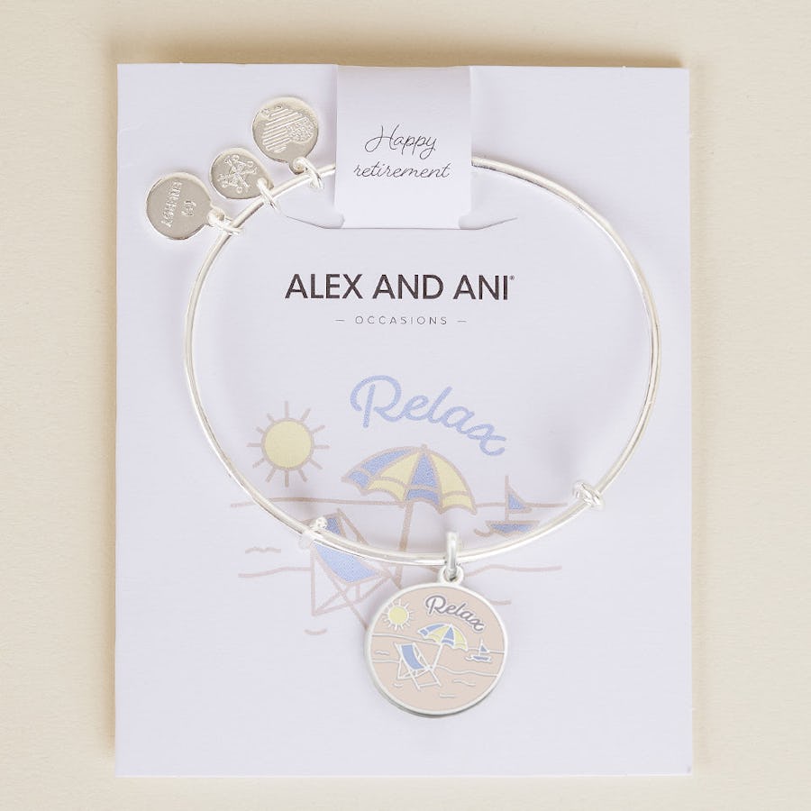 This expandable wire bangle features a circular charm with a beach landscape and the slogan "relax" to commemorate the transition to the next stage.